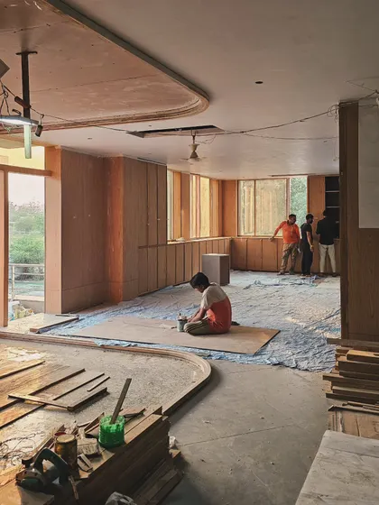 The interior of a project during the wood paneling installation. The natural grain and warmth of the wood begin to define the space, creating an inviting and human-centric atmosphere.
