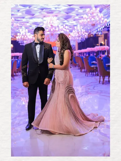 A romantic portrait of the couple, gazing at each other in the middle of the grand ballroom. This shot captures a quiet moment of connection amidst the large-scale celebration.