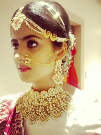 A bride looking radiant in a heavy Kundan choker with a matching matha patti and nath. This is the complete traditional bridal look that I love to create.