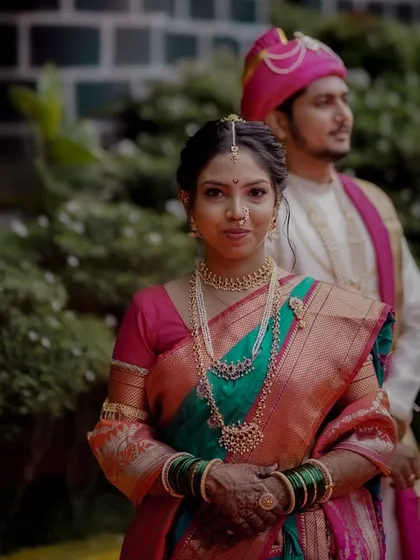 A classic bridal portrait, with the groom slightly out of focus in the background, emphasizing the bride's elegance and poise.