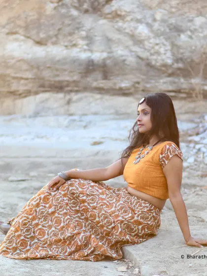 A serene, seated portrait in a rustic setting. The soft light and relaxed pose create a peaceful and beautiful image.