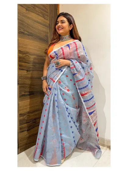 Another Diwali look, this time in a light blue Jamdani saree with red and blue motifs. I paired it with an orange blouse for a fun pop of color and accessorized with silver jewelry.