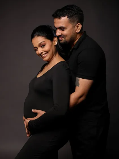 A beautiful pose from behind, showcasing the baby bump and the protective embrace of the partner.