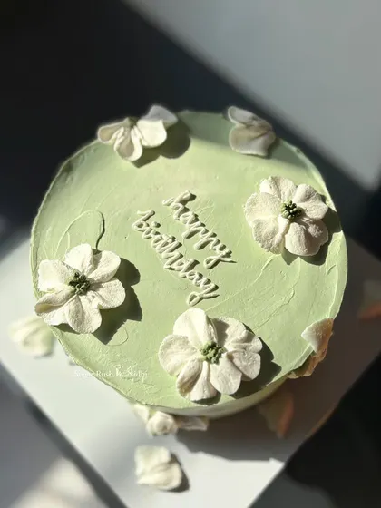 A minimalist cake in a lovely sage green color, decorated with simple, elegant piped flowers. This design is perfect for someone who appreciates understated beauty.