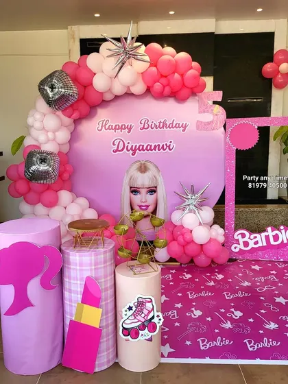 A vibrant pink Barbie theme decoration with a circular backdrop, balloon arch with disco ball accents, and a Barbie photo frame.