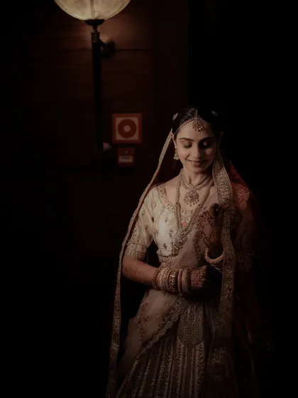 A moody and atmospheric bridal portrait, with the bride looking down, creating a sense of quiet contemplation.