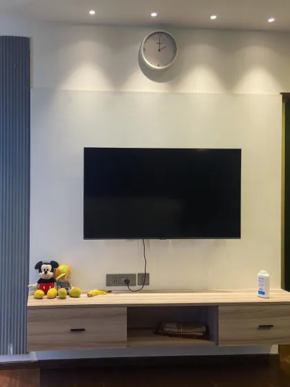 A still shot of the bedroom TV unit, highlighting its light wood finish and simple, clean lines that contribute to the room's serene atmosphere.