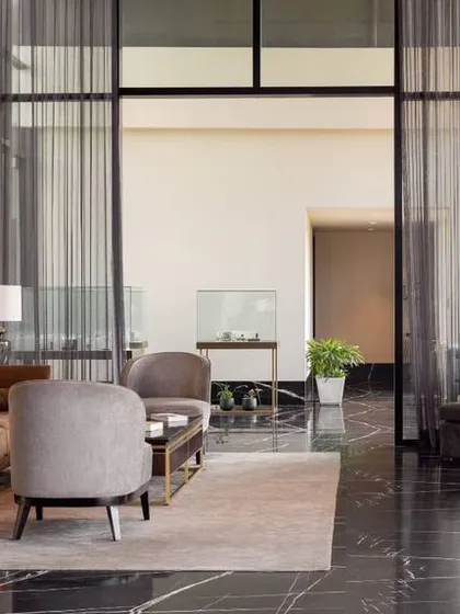 Expansive glass walls and sheer curtains flood the Godrej South Estate lounge with natural light. The layout provides multiple seating areas, ensuring the space feels open and connected while offering intimate zones for discussion.