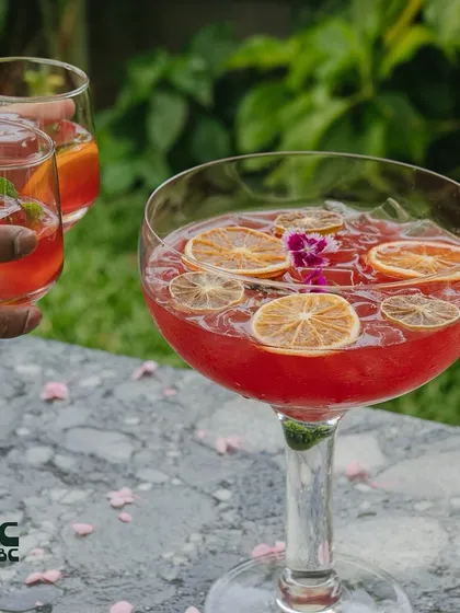 Our Sakura community cocktail is perfect for sharing. It's a vibrant and refreshing mix of sake, gin, and fruit juices.