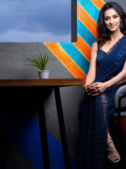 A seated portrait of Radhika Narayan against a colorful, graphic wall. This shot shows how we can use interior design elements to create a vibrant and modern photograph.