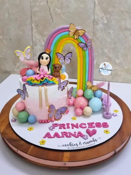 This princess and rainbow cake is packed with detail, from the fondant princess to the colorful spheres and butterflies. It's a perfect example of a small cake that makes a big impact.