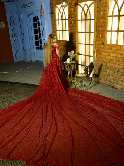 A breathtaking shot of a model in a red sequined gown with a massive, magnificent trail, perfect for a dramatic pre-wedding photo.
