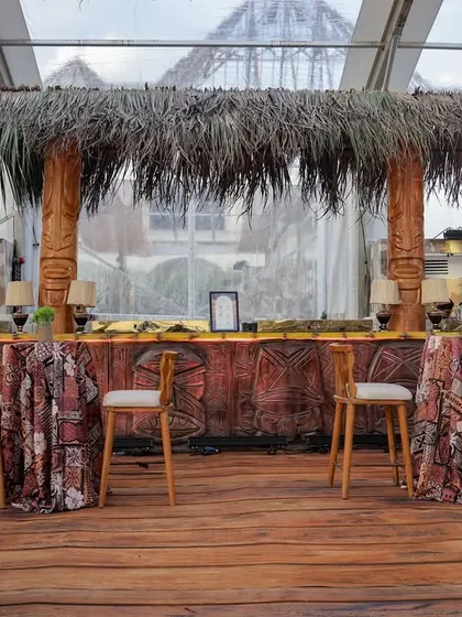 The main bar area, with a thatched roof and a bar front decorated with tribal patterns. This space serves as a central hub for guests to gather and enjoy a drink.