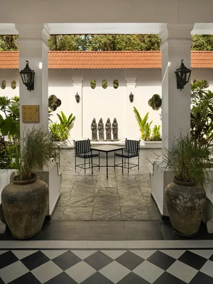 The foyer at Elgin Cafe acts as a threshold between the exterior and interior worlds. Symmetrical columns frame a view into the tranquil courtyard, establishing a sense of formal procession and calm.