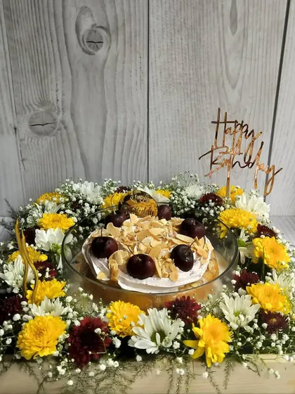Make their birthday truly special with a complete celebration in a box. This floral hamper features my moist Cherry Almond Tres Leches cake, surrounded by a bed of fresh, vibrant flowers and topped with a custom birthday message.