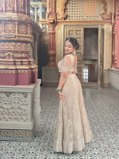 This shot showcases the complete look, including the elegant updo and the way the makeup works with the entire outfit. It's a great example of a polished look for a sangeet or reception.