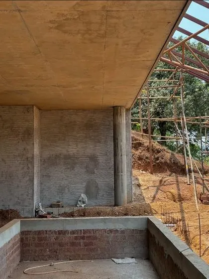 The swimming pool and stage area for the Kaivalyam Yoga retreat under construction. The design uses the site's slope to create two distinct levels for privacy and public functions.