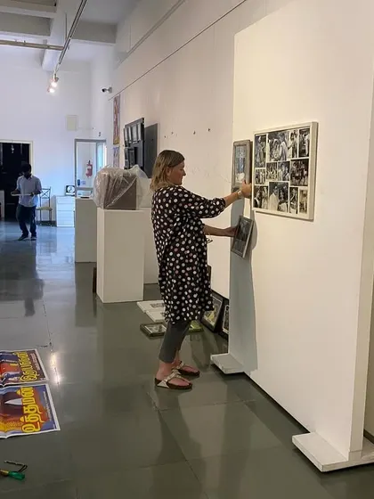 Clare Arni adjusting the placement of works on a temporary wall.
