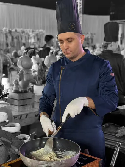 Every dish receives the full attention of our chefs. Here, a member of our international culinary team prepares a creamy sauce, showcasing the focus and skill that goes into each component of our global menu.