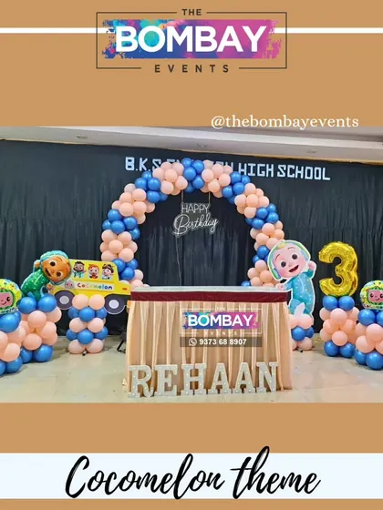 Another fun Cocomelon setup, this time with a semi-arch over the cake table. The design includes character cutouts, a number '3' foil balloon, and the birthday boy's name in light-up letters.