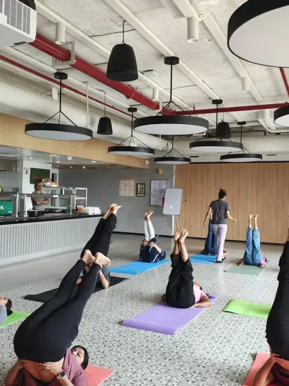 Participants practicing Sarvangasana (Shoulder Stand) variation, an inversion that helps calm the mind and improve circulation.