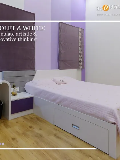 Another view of the violet and white bedroom, showing the integrated study nook and simple, modern furniture. The design is both inspiring and functional.