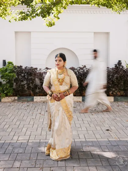 An artistic shot of the bride in focus while the groom walks past as a motion blur, creating a dynamic and modern traditional portrait.