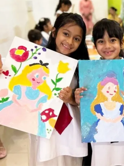 Down the rabbit hole we go! Two young artists proudly display their "Alice in Wonderland" canvas paintings. We pre-sketch designs to help guide the kids while letting them choose their own colors.
