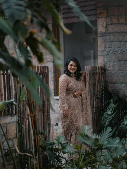 A candid moment captured through the foliage. Her natural-looking makeup ensures she looks beautiful from every angle.