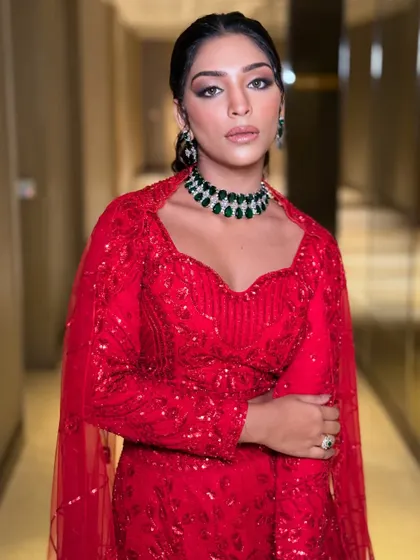 A full-length shot of the model in the red lehenga, showcasing its vibrant color and modern design.