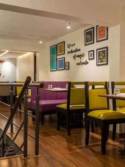 A view from the mezzanine level at the Cunningham Road location, looking down into another dining section. This split-level design creates distinct zones, with vibrant furniture and quirky wall quotes adding personality to the space.