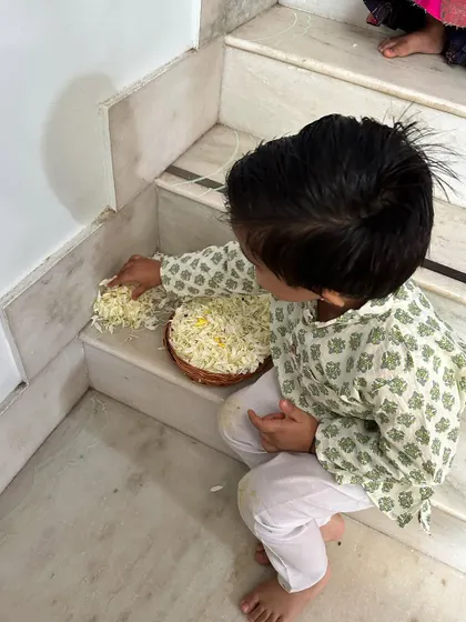 A moment of quiet concentration as a child prepares materials for our festival decorations.