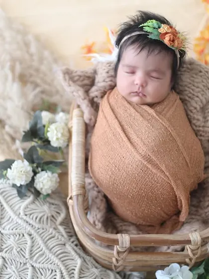 Another beautiful shot from our boho collection. The focus here is on the baby's peaceful expression and the lovely textures of the knitted blankets and woven basket.