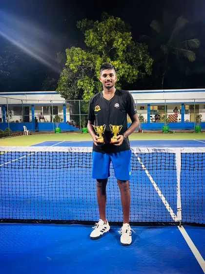 A night shot of our player Manish with his two trophies, celebrating a hard fought victory under the lights.