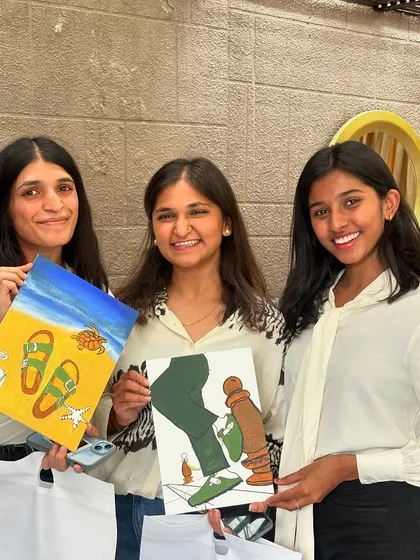 Three guests proudly showing off their finished paintings at the Birkenstock event. The custom designs were a huge hit.