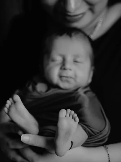 A precious black and white close-up of a newborn's sleepy smile and tiny feet. These detail shots are essential for remembering just how small they once were.