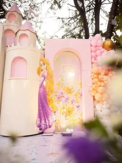 A closer look at the princess castle setup, featuring Rapunzel alongside a custom-designed floral arch and a colorful balloon garland. I love mixing different princess elements to create a cohesive royal theme.