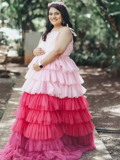 This mother-to-be is wearing our popular tri-color ombre gown with pink and red layers, a playful and eye-catching choice for an outdoor shoot.