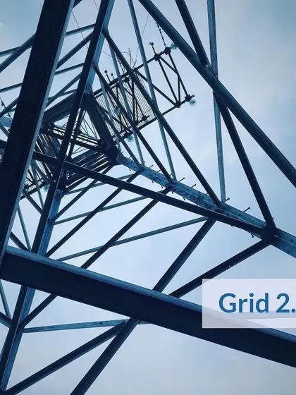 A view looking up an electrical transmission tower, representing the traditional power grid. Our work focuses on creating "Grid 2.0," a more intelligent, decentralized, and efficient energy ecosystem.