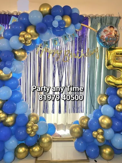A blue and gold balloon arch with a number '5' foil balloon for a simple home birthday party.