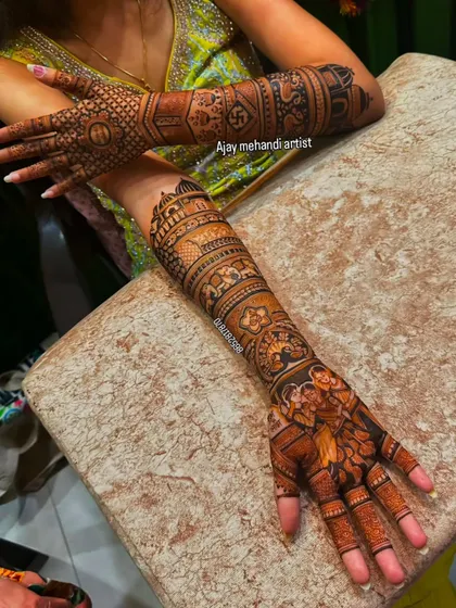 A dense bridal design with traditional Indian motifs, including elephants and a swastika for good luck.