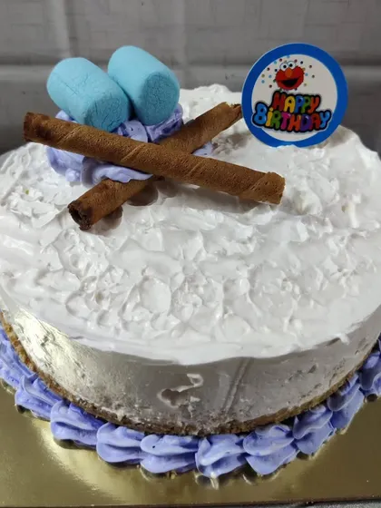 A simple birthday cheesecake topped with wafer rolls and blue marshmallows.
