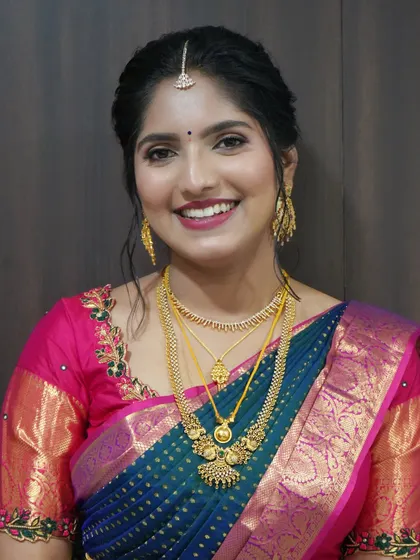 Vindya's bright and happy look for her Varapooje. The pink and blue saree is complemented by a glowing makeup look and a cheerful smile.