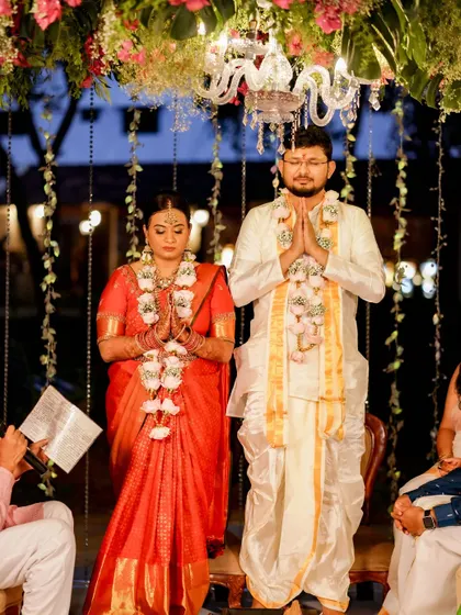 A serene moment of prayer during the wedding ceremony, with the couple framed by our elegant floral and light decor.