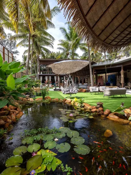 A serene, natural pond teeming with life becomes the centerpiece of this outdoor living design. We crafted this space to be a private oasis, blending manicured lawns with wilder, natural elements for a truly immersive experience.