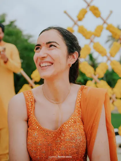 The bride, Eli, with a radiant smile during her Haldi ceremony. The bright, festive colors of the event make for visually stunning footage.
