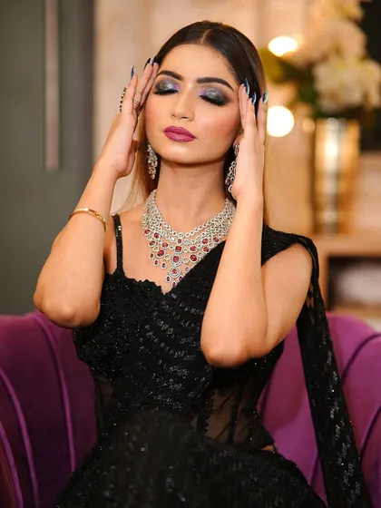 Eyes closed to show the full effect of the dramatic smokey eye. The glitter and deep colors create a look that is pure glamour.