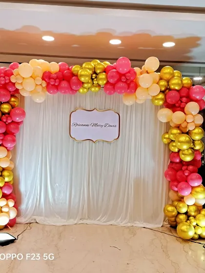 A simple balloon arch in pink and gold for Roseanne's baptism ceremony. This provides a beautiful and celebratory photo backdrop for the special day.
