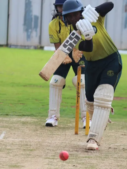 A low-angle shot capturing the moment of impact as the bat meets the ball.