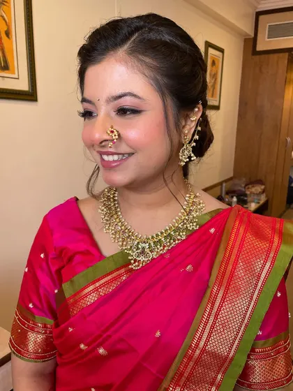 A beautiful, smiling portrait. The winged eyeliner and traditional nath add a touch of classic glamour to this fresh and modern look.